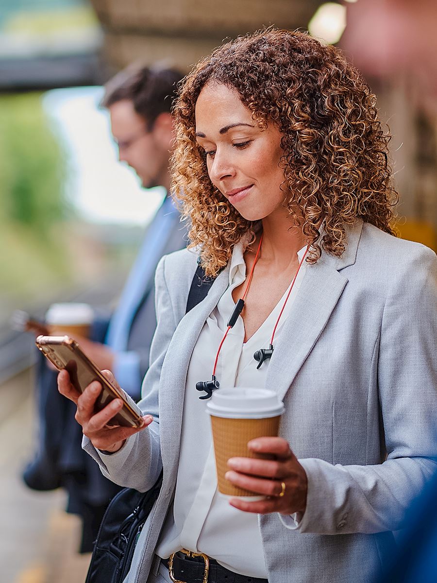 Lady holding coffee while on cellphone